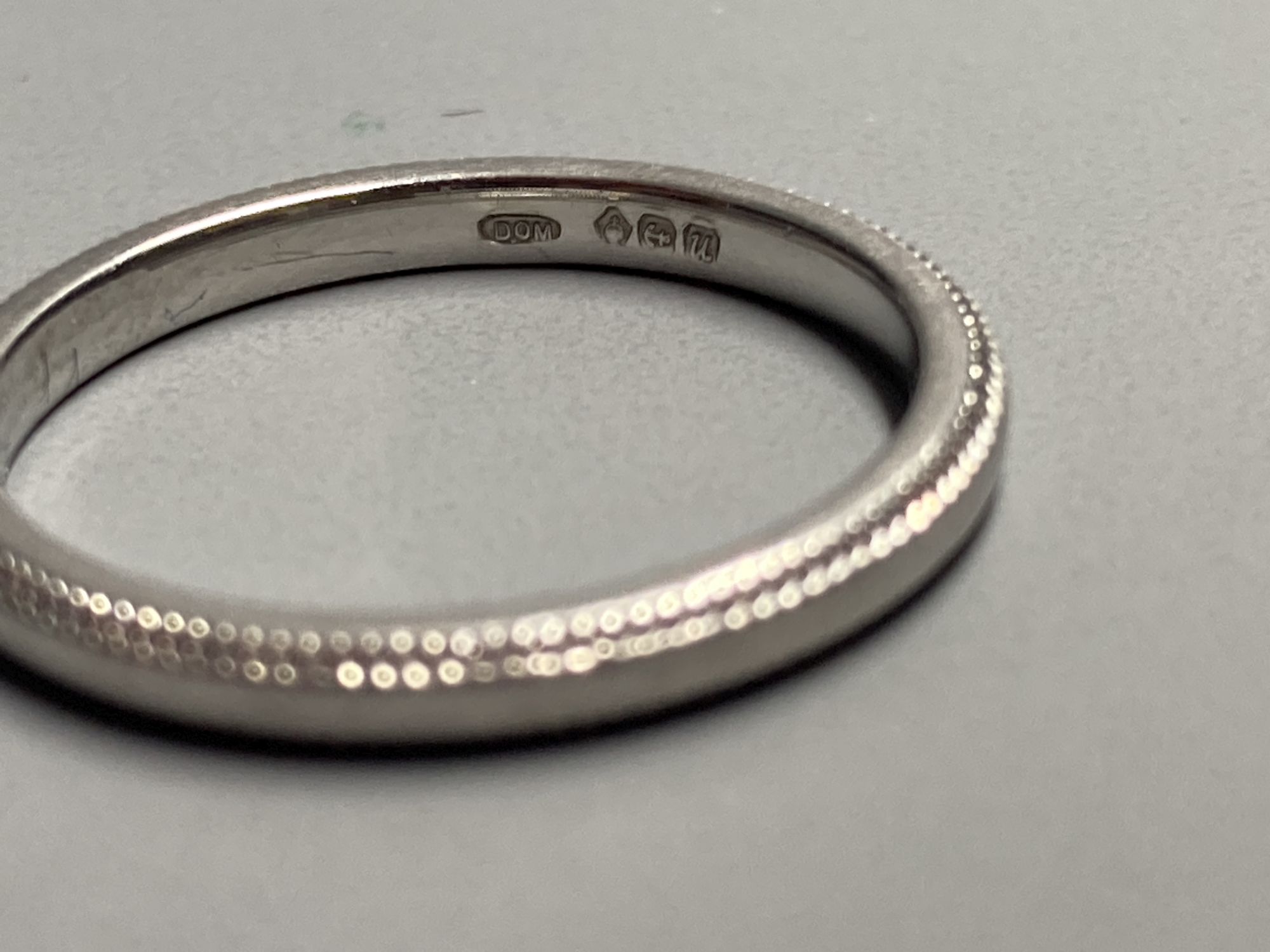 A modern platinum wedding band with milled edges, size L, 3.2 grams.